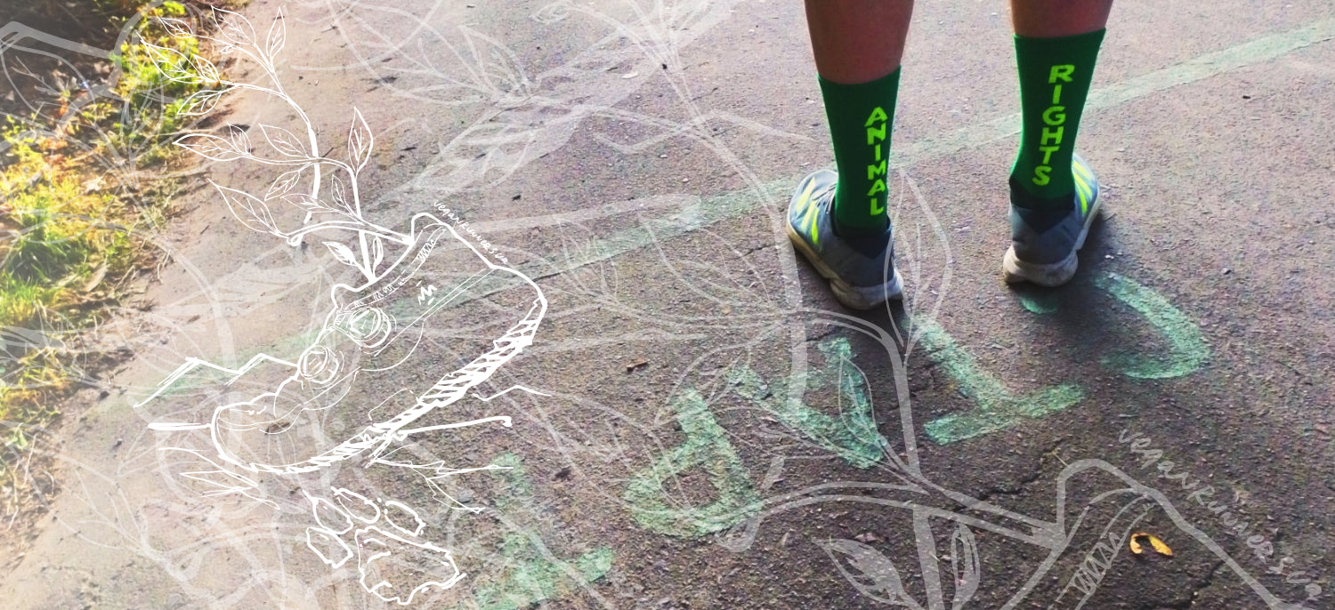 Vegan person runner roadrunner trail runner wearing green Animal Rights socks with text standing on a running path.